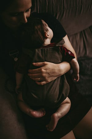 mãe abraçada com a bebê